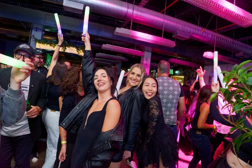 Guests dancing under pink club lights at Back to the 2000s Auckland